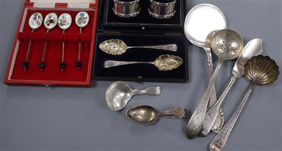 Three cased stes including silver and enamel spoons and napkin rings and six items of silver/white metal flatware.